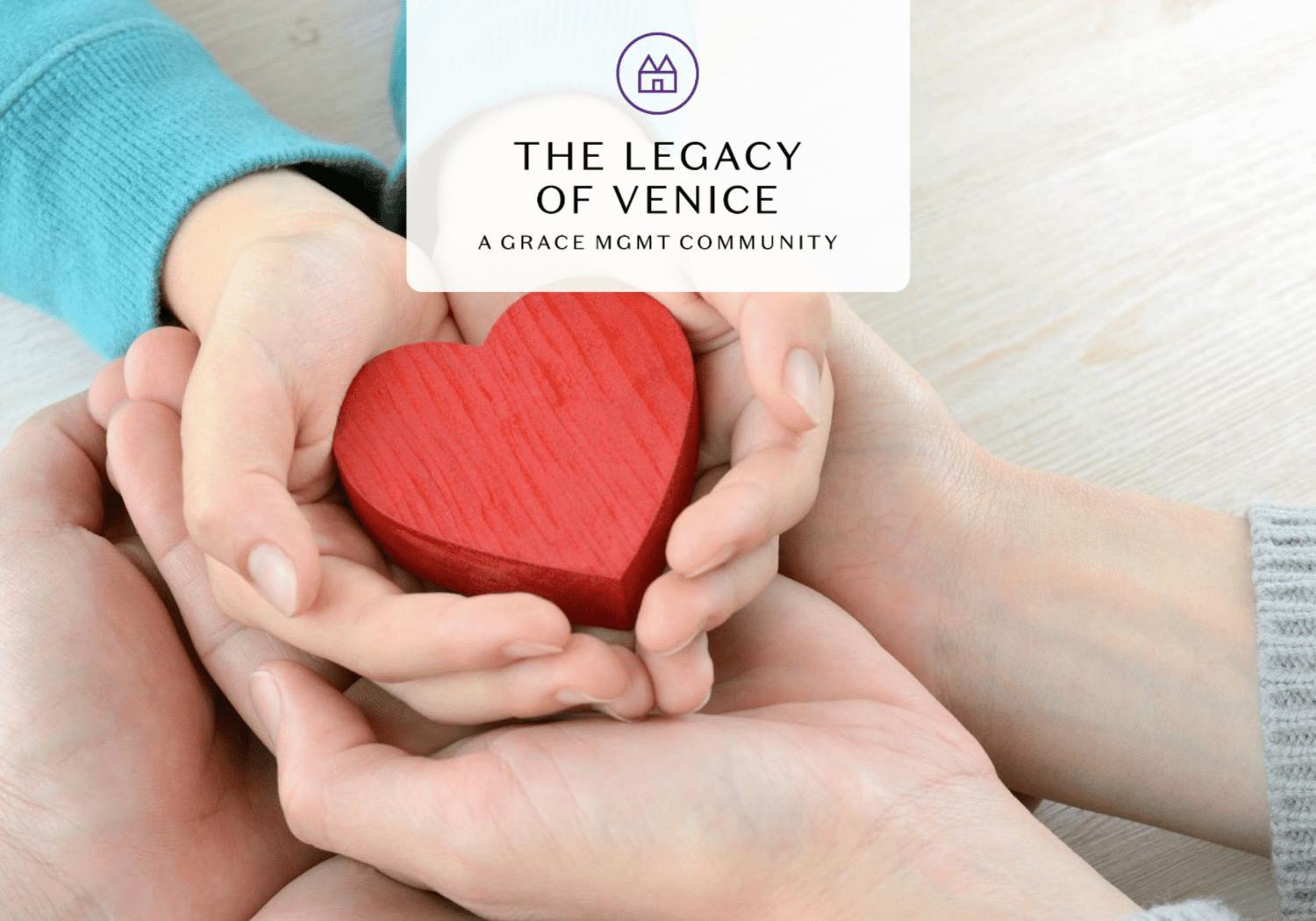Multiple hands cupping a red wooden heart, symbolizing care and support.